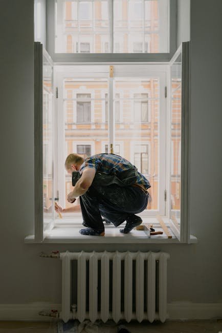 A handyman engaged in window repair work, focusing on craftsmanship.